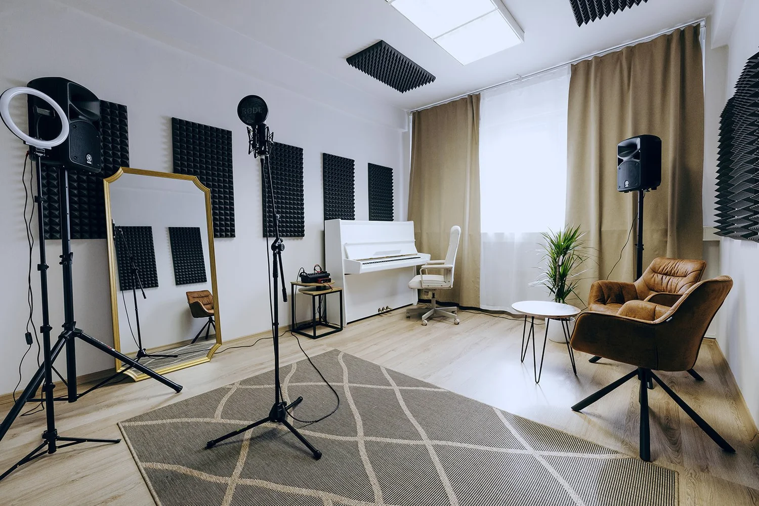 Bright Singasong studio with a piano, microphone and acoustic panels