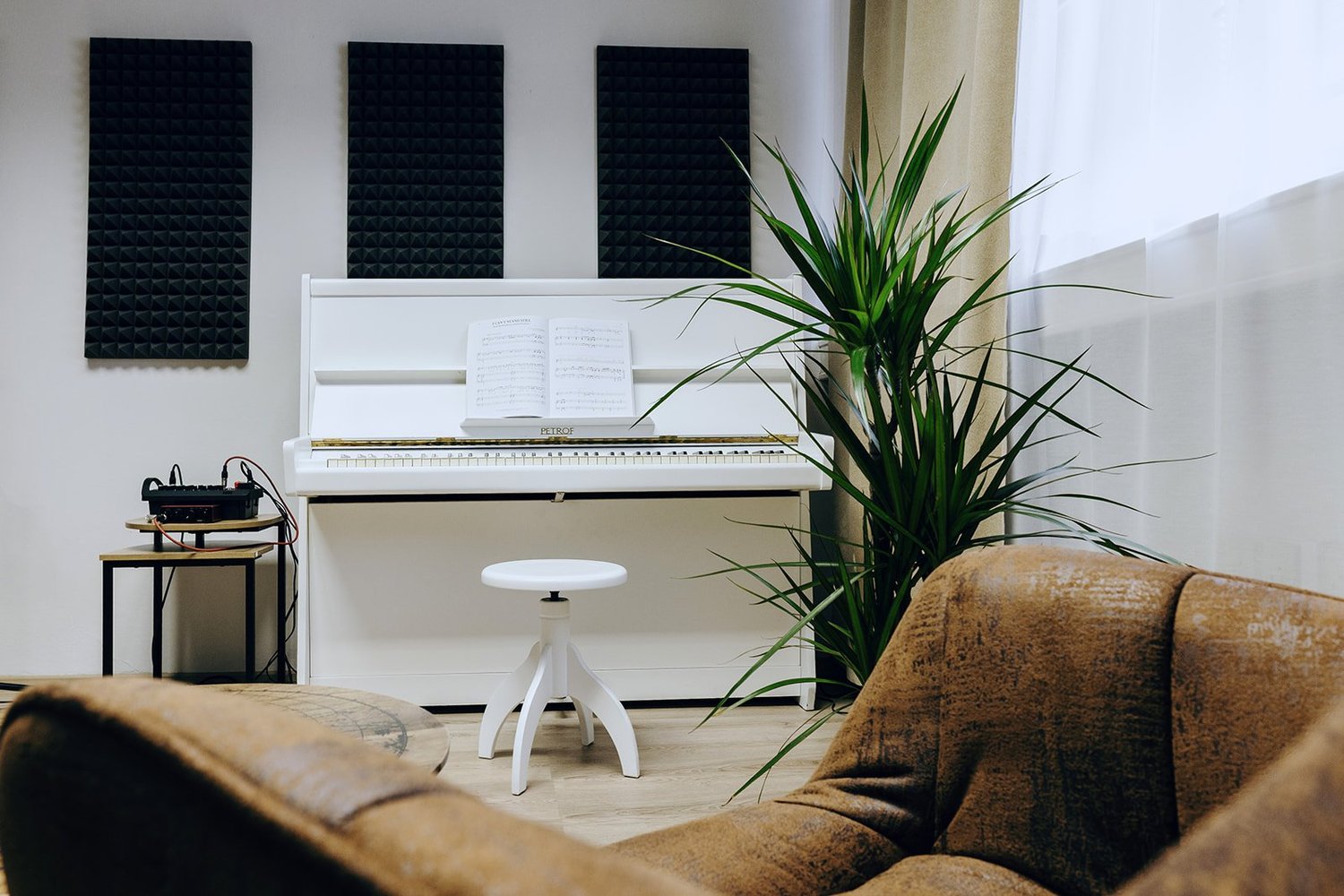 White piano and seating area in the bright Singasong studio