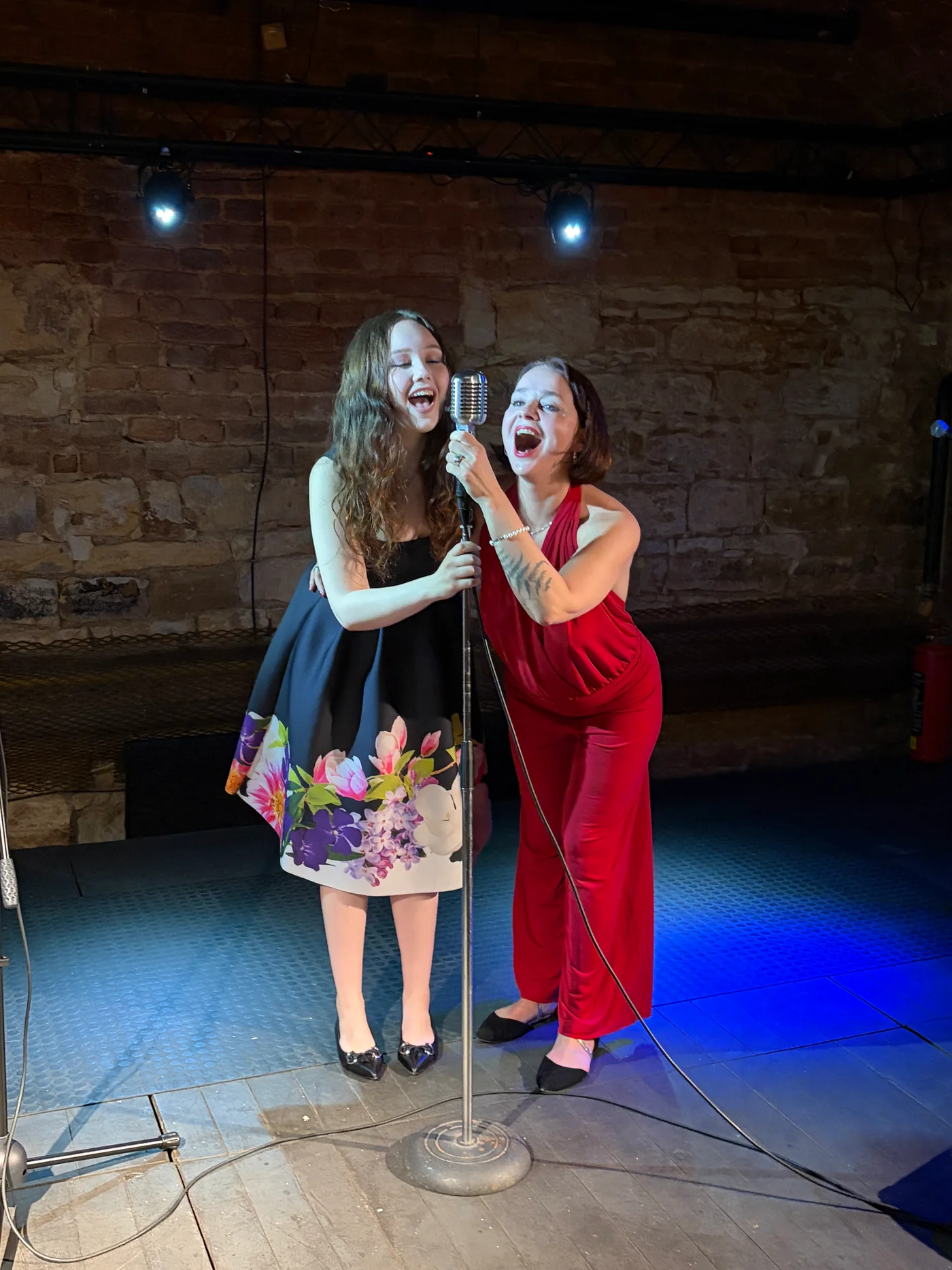Two singers sharing a microphone on stage